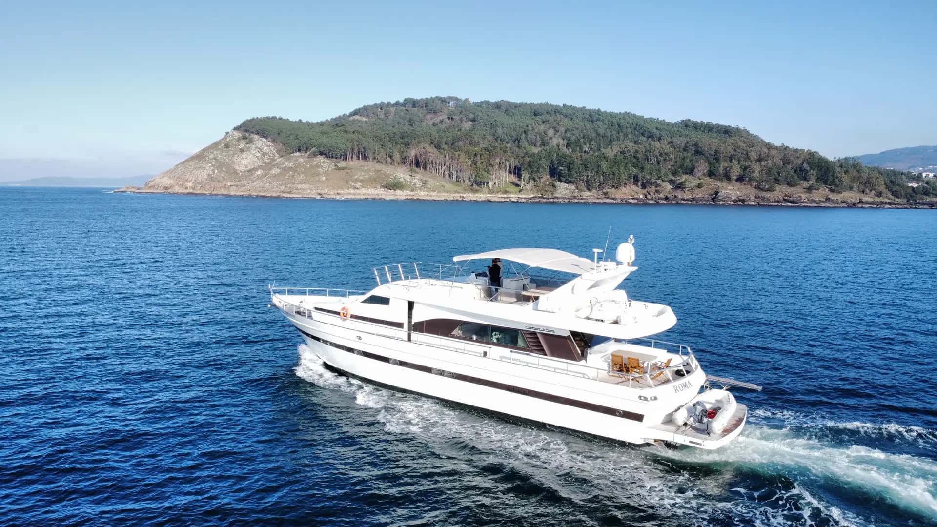 Yate navegando por las Rías Baixas con una isla al fondo